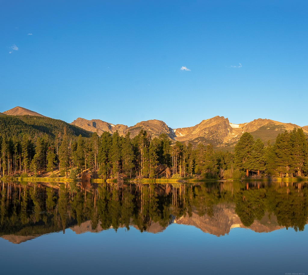 Full reflection of the mountains and forest in the lake