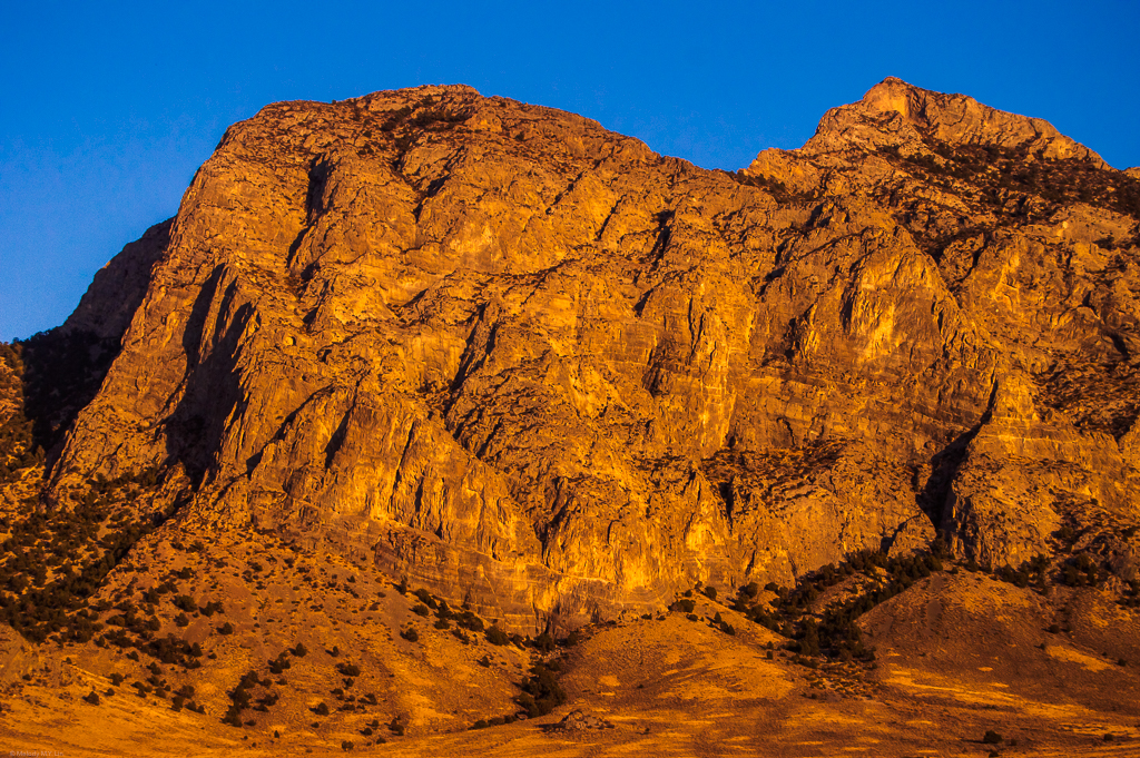 A big wall of mountain in sunset orange