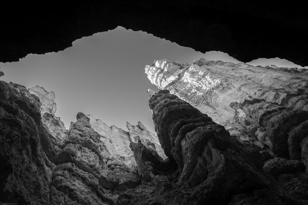 The roof of the canyon wall creates a deep shadow in the shape of a mountain peak.