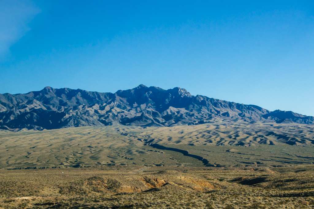 Desert mountain range rising from sea level.