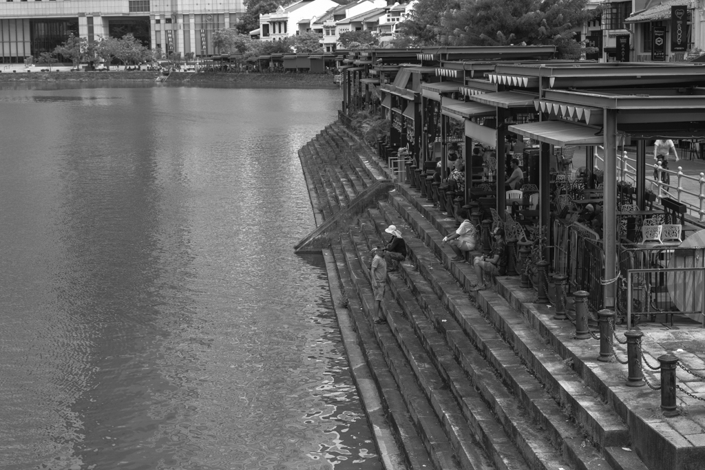 Locals sitting on the steps by the river