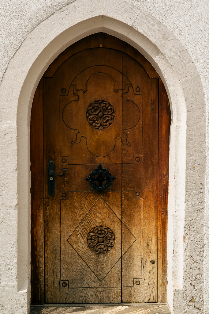 A heavy wooden door with intricate carvings