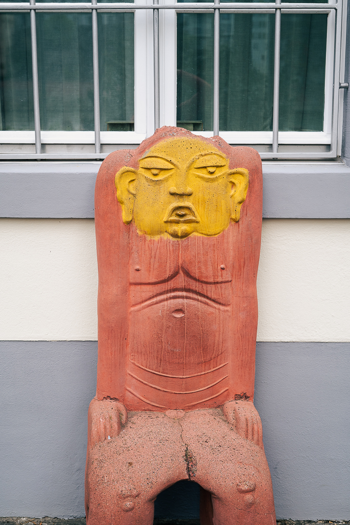 An interesting red chair with the face of a Buddha