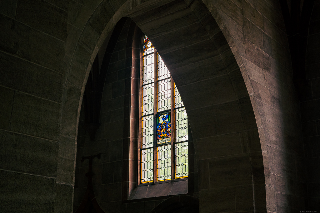 Looking through an arch to a stained glass window