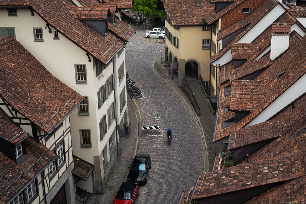 A biker rides down the cobblestone streets