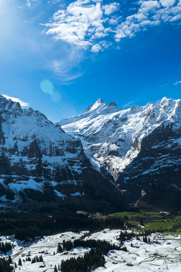 A view looking down the snow into the valley and up at the Schreckhorn