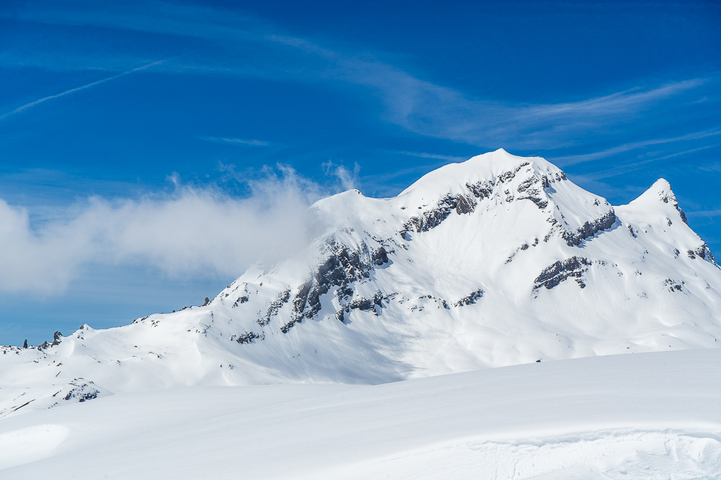 A thin layer of clouds settling over the mountainside