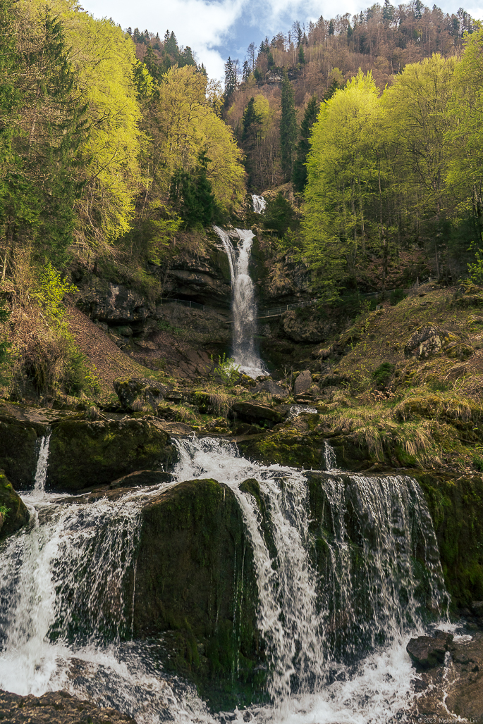 Waterfall drops multiple stages over the hillside