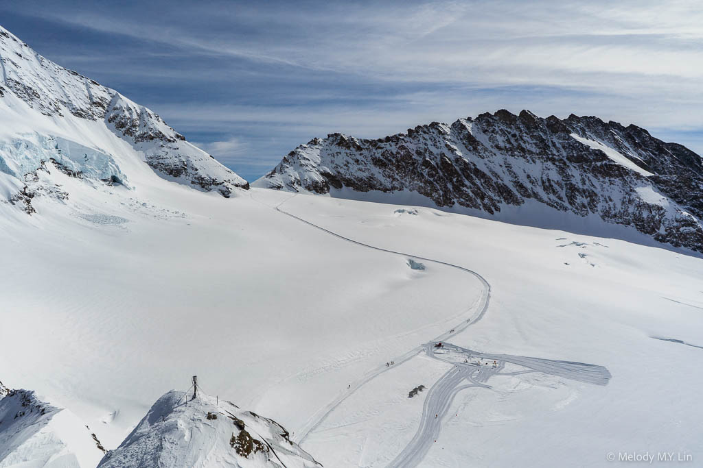 People hiking through the snow field below