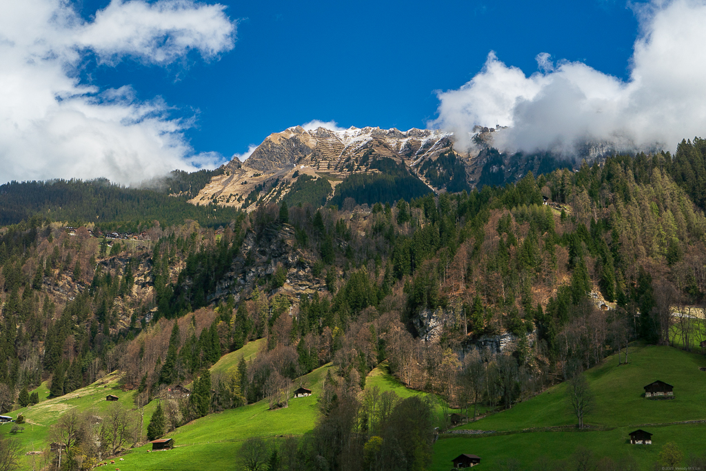 Green hillsides and peaks with snow