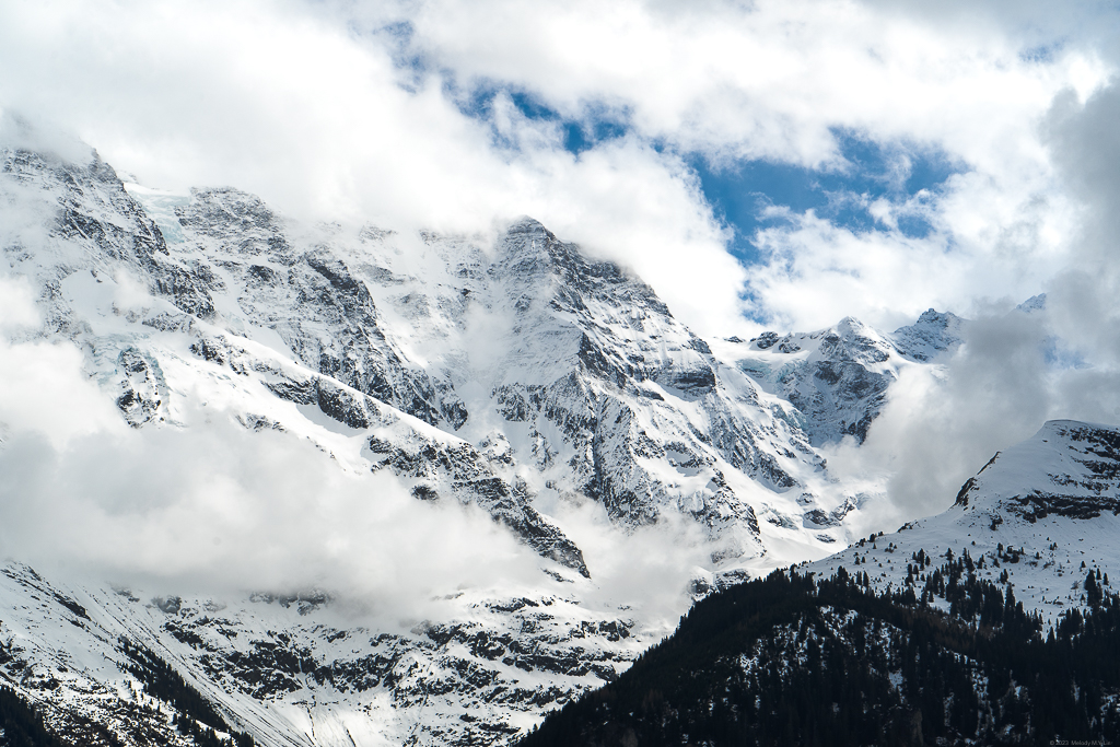 The surrounding peaks, covered in snow