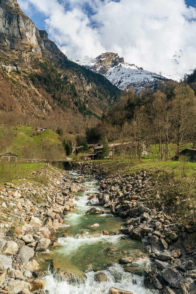 A stream flowing over a rock bed, layers of mountains in the background