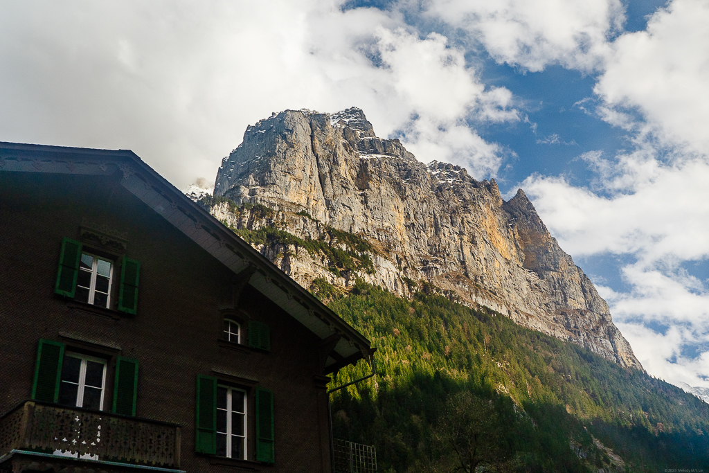 A traditional barn house with the tall, granite cliffs in the back