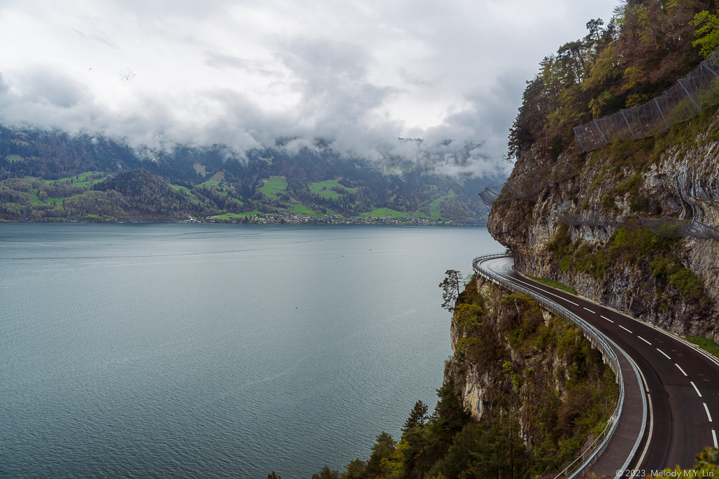 The road above the lake wraps around the cliffs