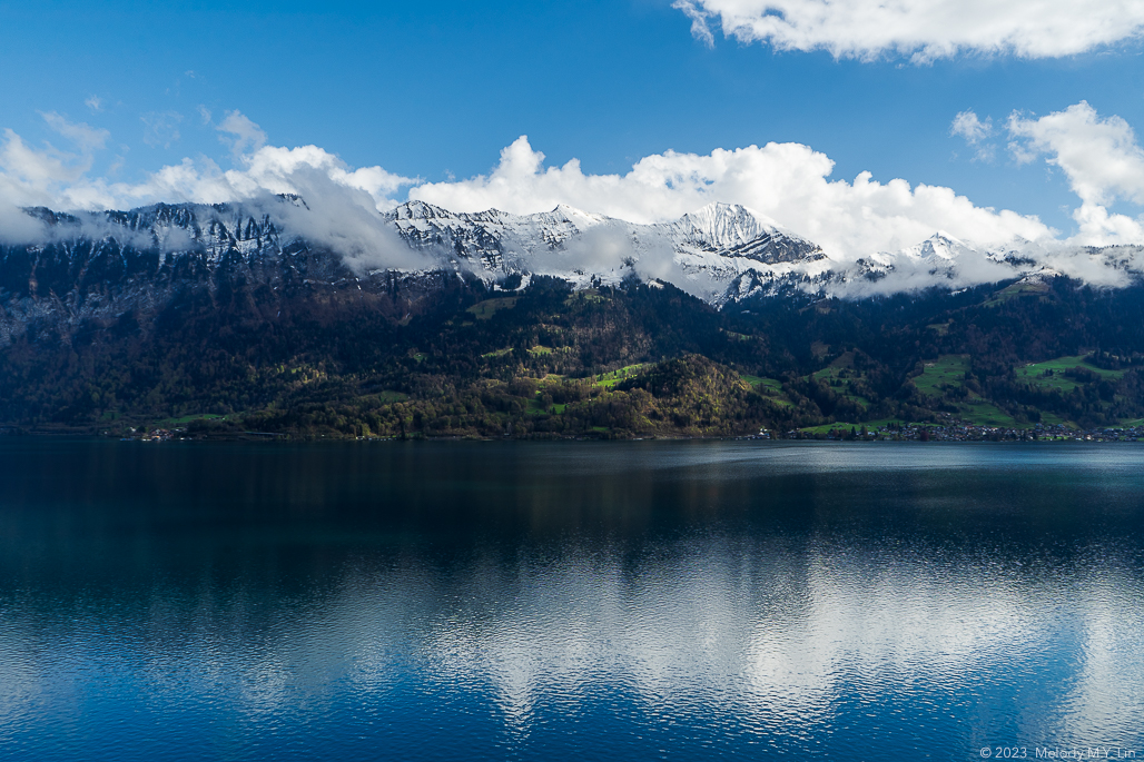 Reflection of the clouds and the Alps on the lake