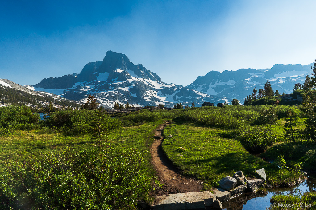 The trail cutting through a lush meadow