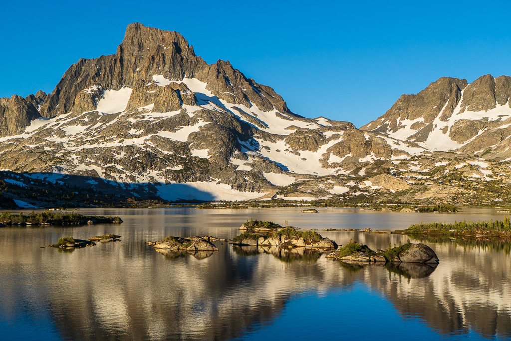 Sunlight hits the little islands on the lake.