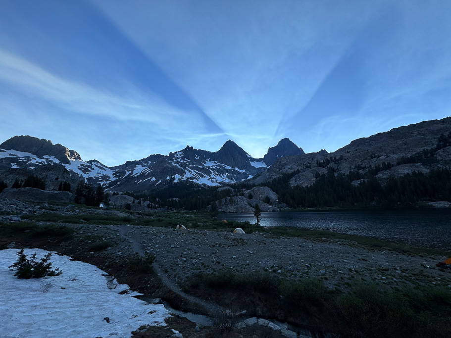 Rays of light shooting out from between the mountain saddle